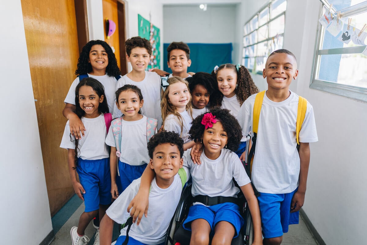 Multiple children posing together in a school hallway.